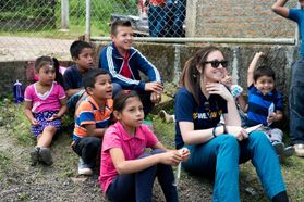A WVU student who is part of the Global Brigade sits with children in Nicaragua.