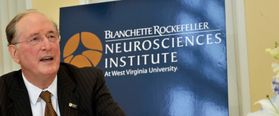 Former U.S. Sen. Jay Rockefeller in front of the Blanchette Rockefeller Neurosciences Institute sign