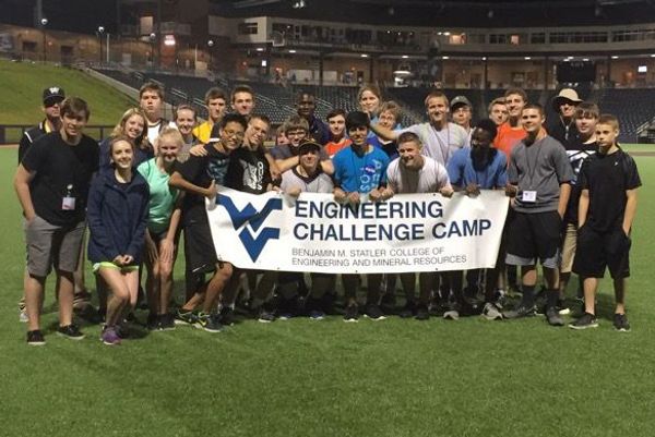 Boys and girls standing with WV Engineering Challenge Camp banner
