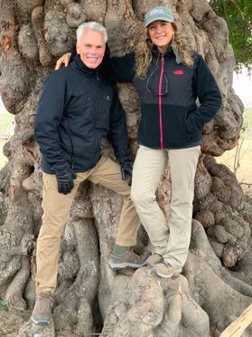 couple stand together outside on old tree roots