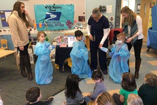adults work with kids dressed in scrubs gowns