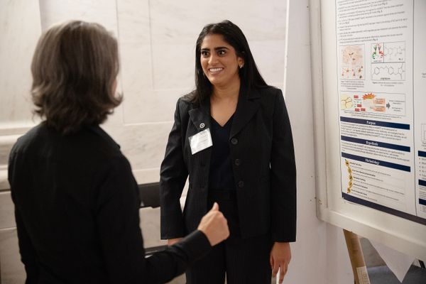 Laasya Chennuru discusses her research while standing in front of a poster during Undergraduate Research Day at the Capitol.