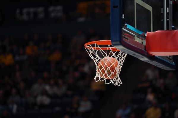 A basketball goes into a basketball rim