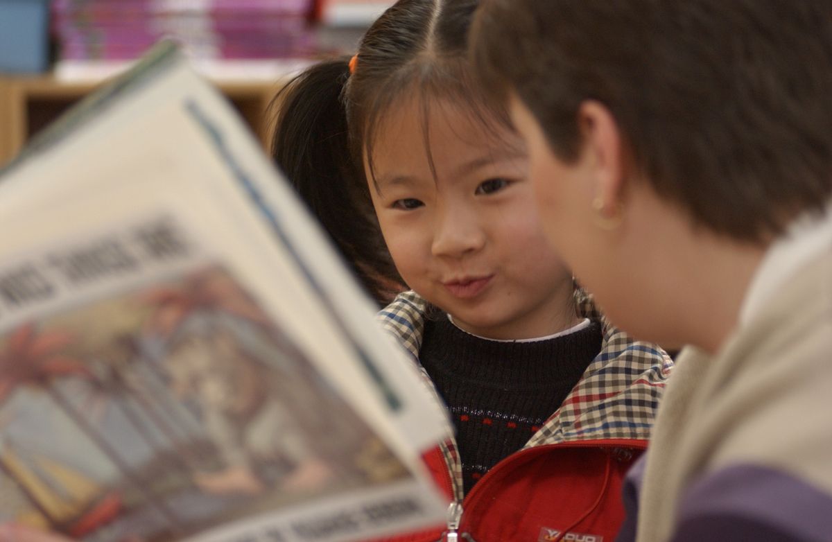 An Asian child looks at the book, 