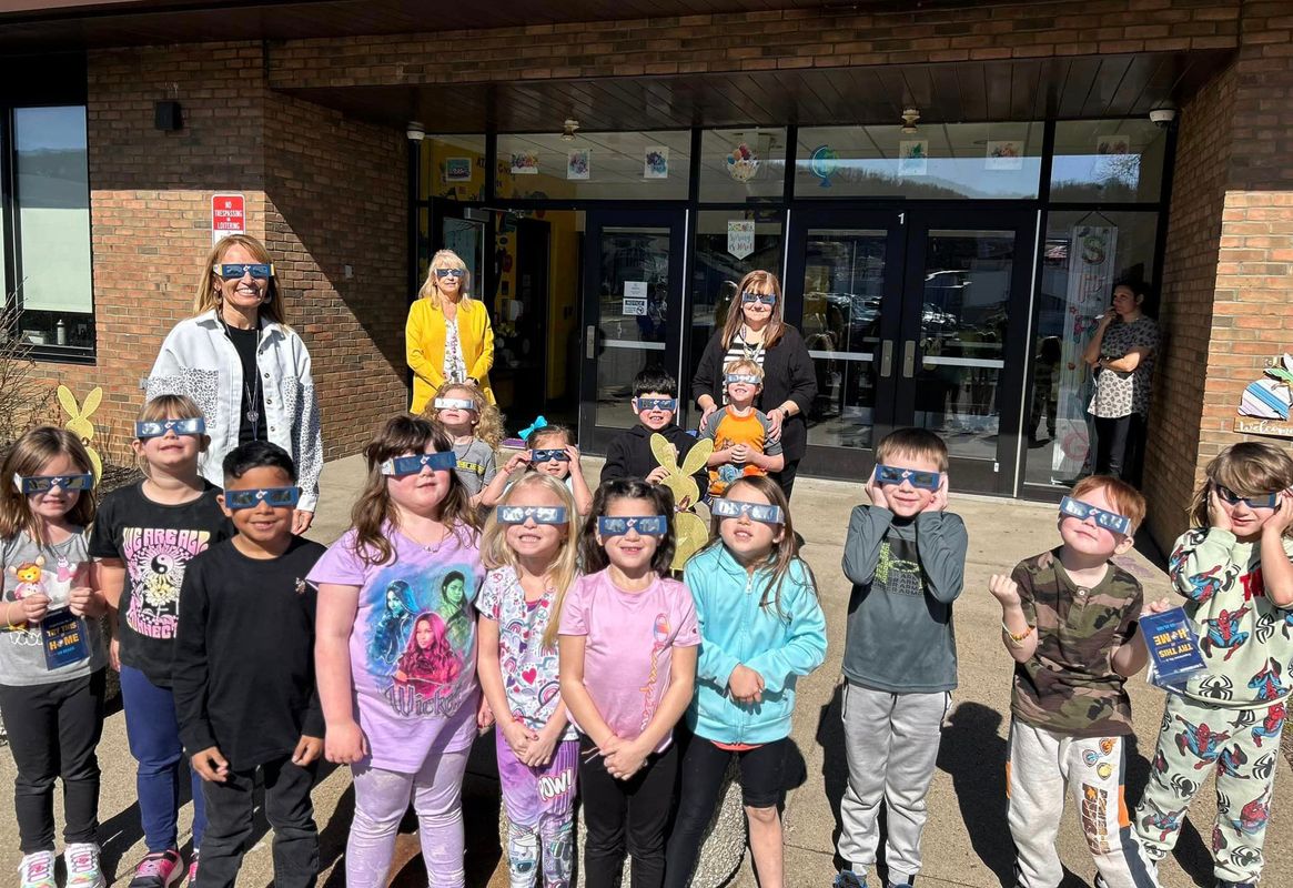 Elementary school students stand outside in their solar eclipse glasses provided by WVU Extension STEMCARE.