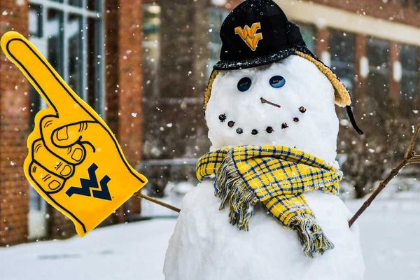 Snowman stands outside with WVU hat, scarf and foam finger.
