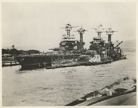A black and white U.S. Navy photograph showing the extensive damage to the USS West Virginia following the attacks on Pearl Harbor during WW II. 