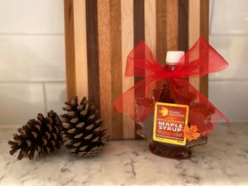 Maple syrup with pine cones and a bow