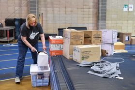 Woman in navy shirt and jeans packaging boxes