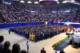Students stand at graduation ceremonies
