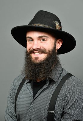 Smiling man in fedora with grey shirt and suspenders