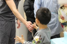 Child holds water syringe
