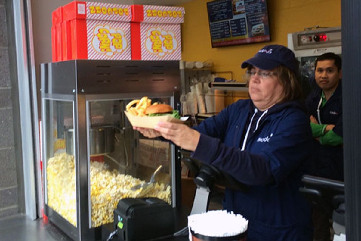 Concession worker serving food at WVU.