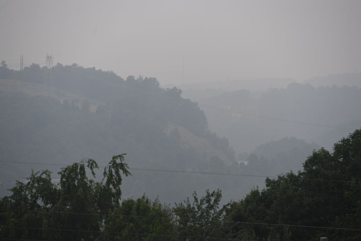A photograph of mountains blanketed in smoke. 