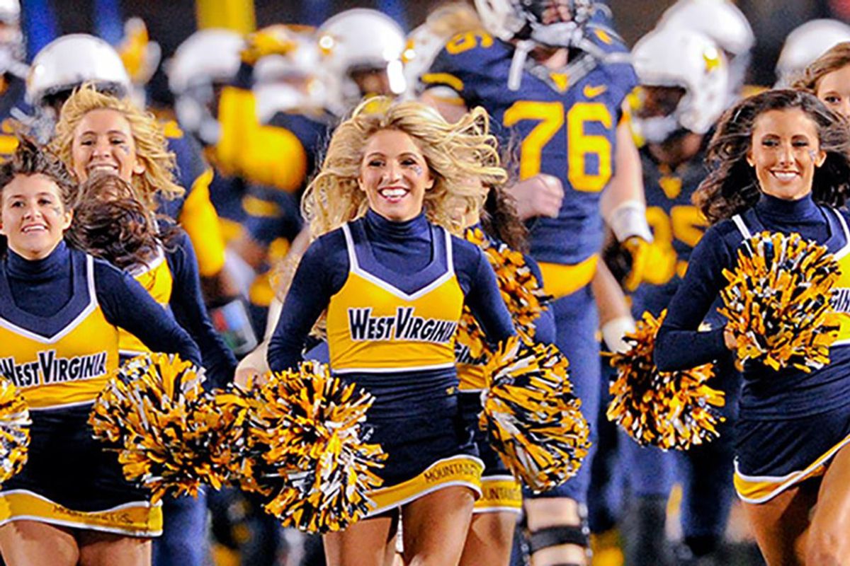 female cheerleaders running with pom poms in their hands