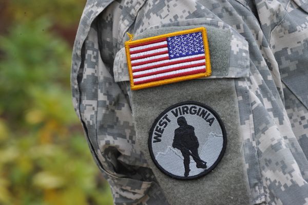 Sleeve of an ROTC uniform with American flag and West Virginia patch with a soldier in sillhouette