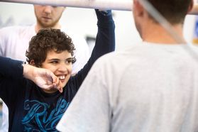 Young boy plays with WVU Lifetime Activities student mentor