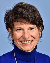 photo of smiling woman with short hair, bright blue turtleneck top
