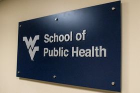 A blue sign on the wall stating, "School of Public Health" in white lettering.