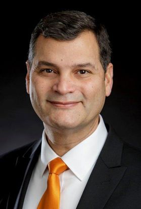 Man in black suit, orange tie and white button-up shirt
