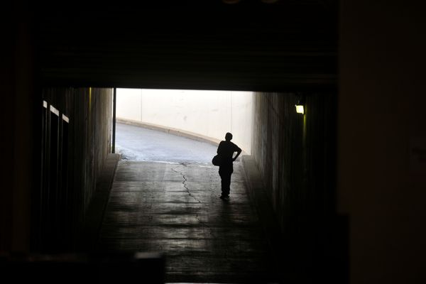 A person walks in a dark tunnel toward light