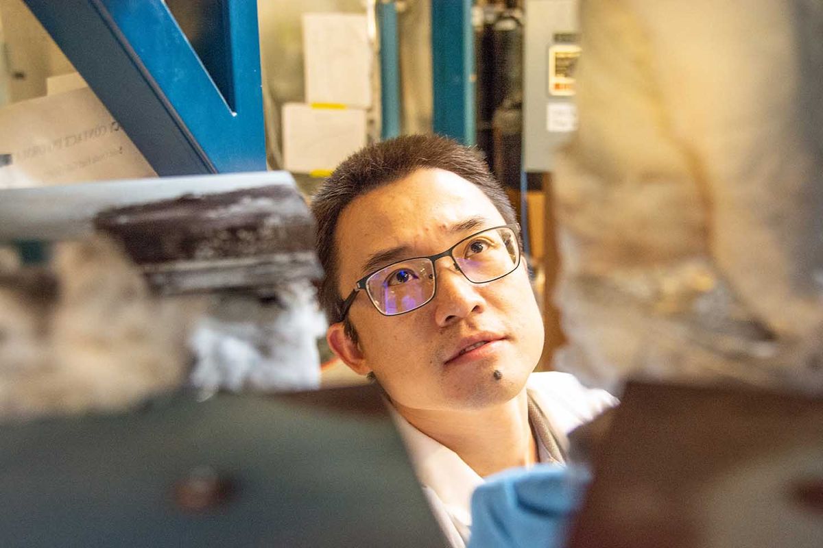 man with glasses looks up in lab setting