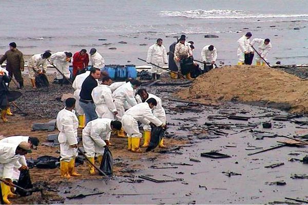 people in white coveralls on a dirty beach