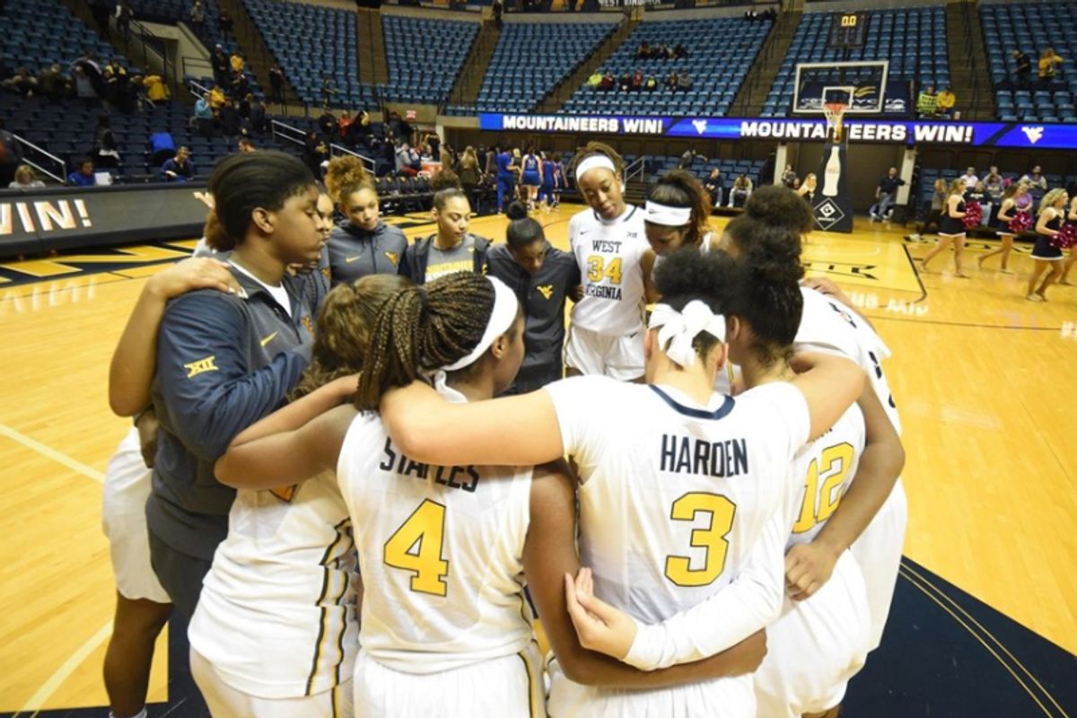 WVU women's basketball team huddles up during a game