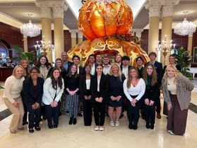 A group of hospitality students pose together inside the lobby of the Nemacolin resort. 