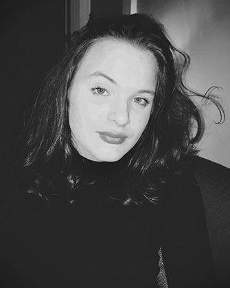 Headshot of WVU Fulbright Scholar Lauren Young. The black and white photo features Lauren dressed in a black turtleneck, with long dark hair. 