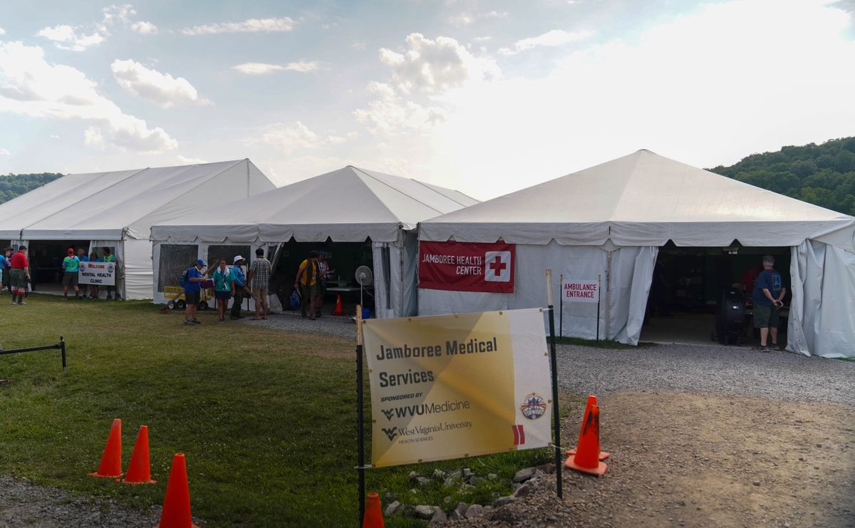 The Jamboree Health Center is shown at the Summit Bechtel Reserve. White tents are in the background. At the front, there is a sign reading 'Jamboree Health Center,' WVU Medicine, WVU Health Sciences.