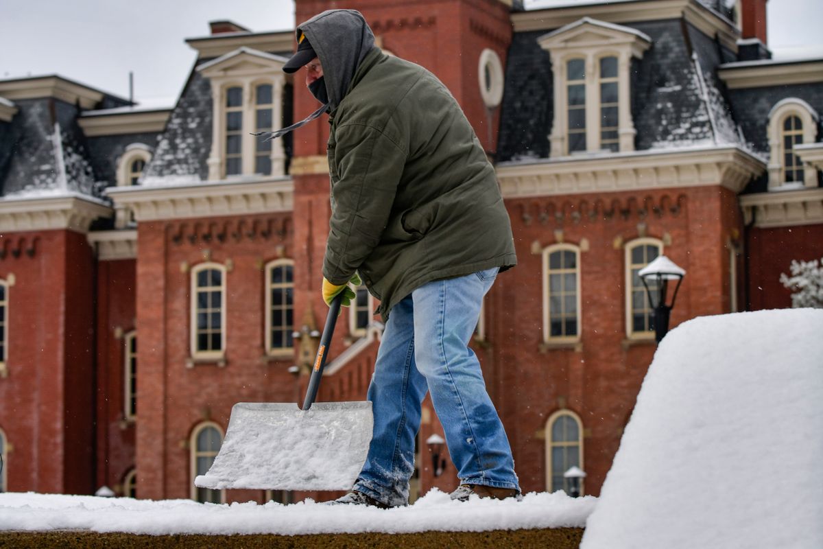 man shovels snowy steps