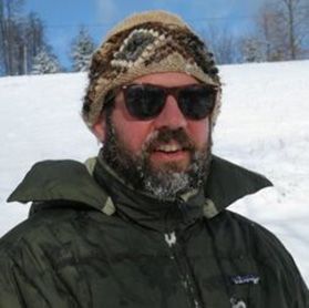Headshot of WVU researcher Walter Veselka. He is pictured outside in snowy conditions wearing a winter hat, glasses and an olive green colored winter coat. He has a salt and pepper beard. 