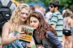 New students look through the Guide to Graduation as they attend the Eberly College academic session on the Life Sciences Green during Welcome Week 2016.