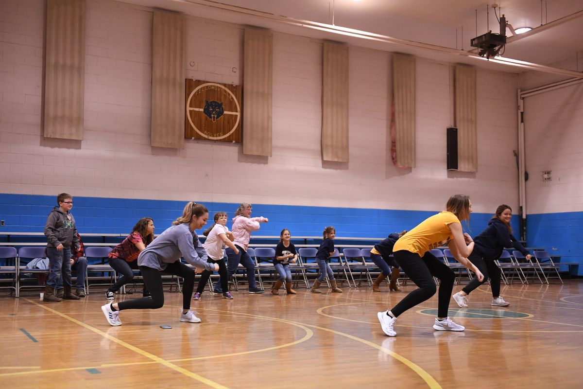People spread out in a gym dancing.