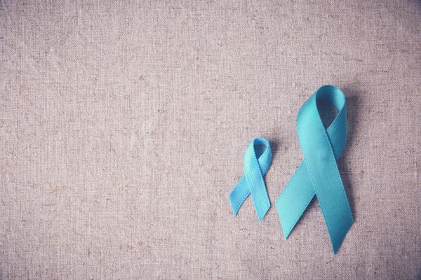 Two teal ribbons on dun colored background