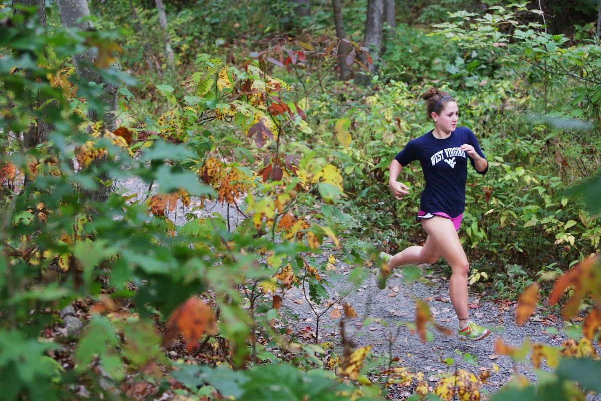 woman running on trail in woods