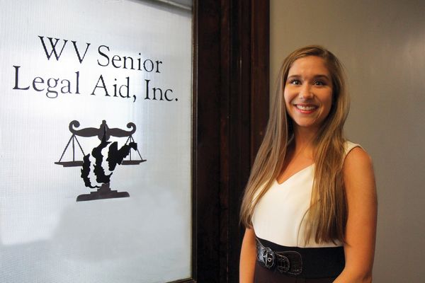 Law student standing in front of door with WV Senior Legal Aid, Inc. on it.