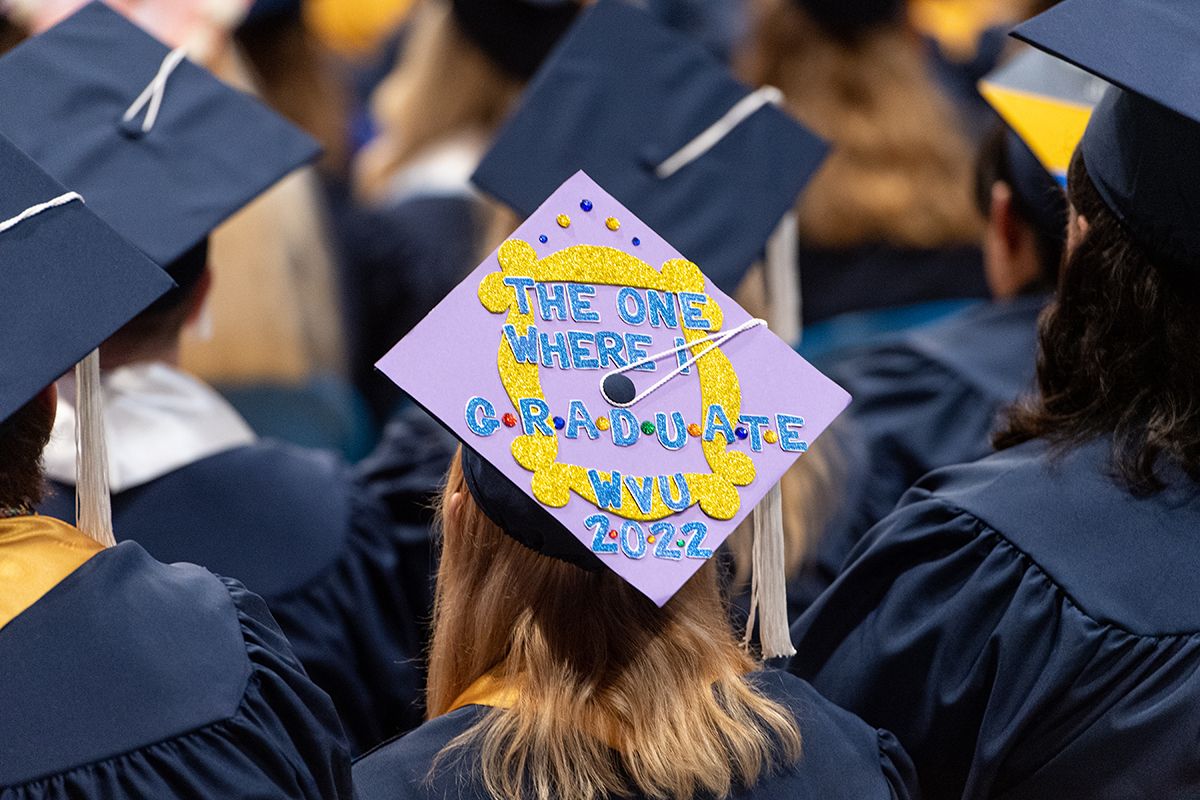 A female graduate wears a cap that says 