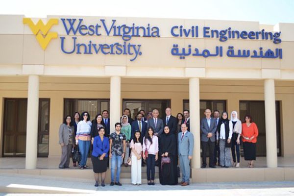 Large group of people standing on a porch; flying WV West Virginia University Civil Engineering above on the building