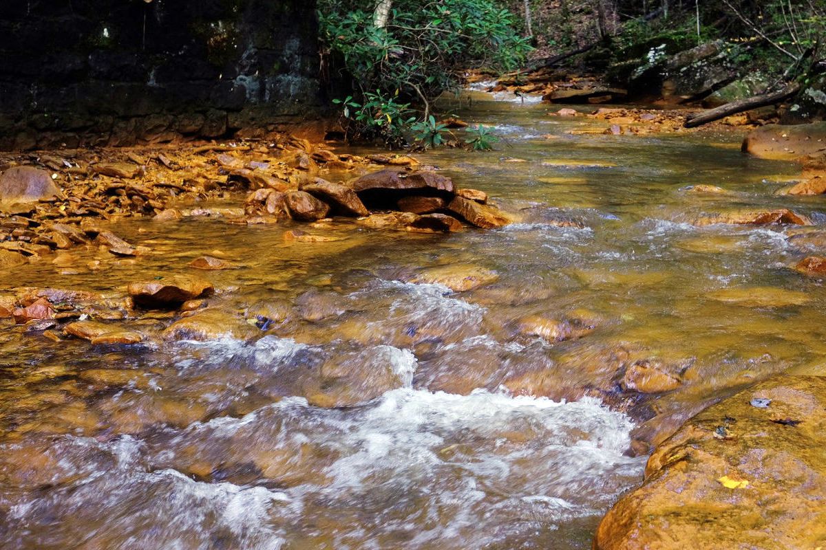 stream with appearance of orang substance on banks