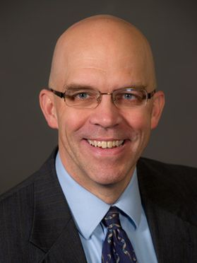 smiling bald man with glasses