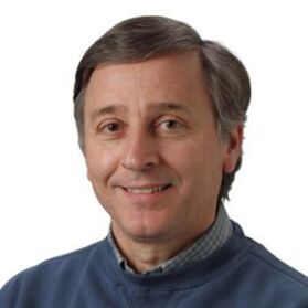 Headshot of WVU Professor Terry Gullion. He is pictured against a white background and is wearing a blue sweater with a plaid dress shirt underneath. He has short brown and gray hair. 