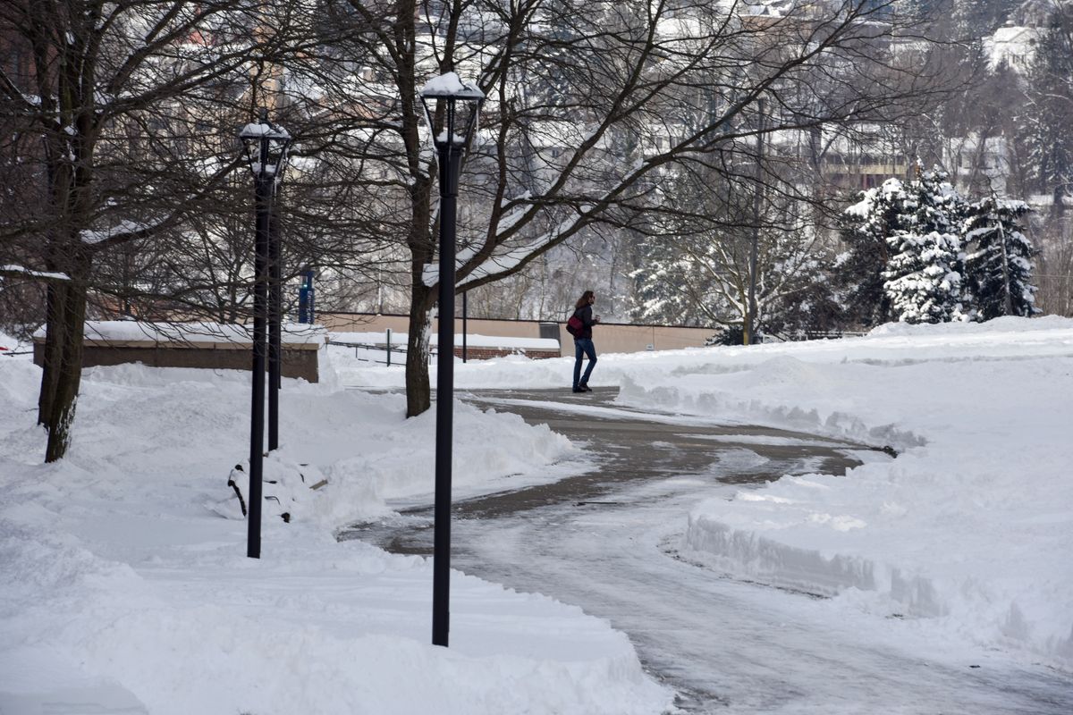 Student walks on snow covered path on WVU's downtown campus.