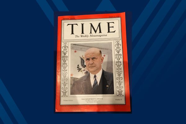 photo of TIME magazine cover with red border and man in dark blue suit