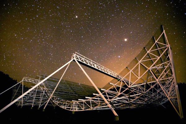 Large telescope under a starry night sky.