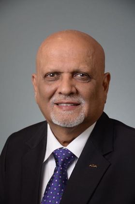 bald man wearing black jack, white shirt and purple tie