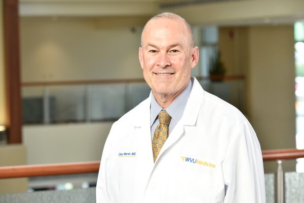 Photo of man with gray hair standing in WVU Medicine white lab coat