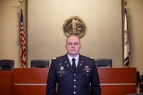 soldier stands at attention in a courtroom