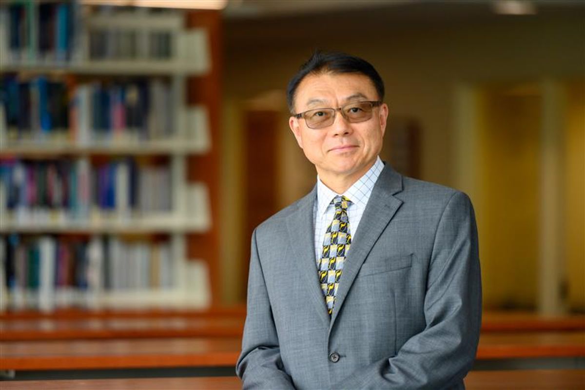 Headshot of WVU admistrator Ming Lei. He is pictured inside wearing a gray coat over a white dress shirt with a multi colored tie. He has short black hair and glasses. 